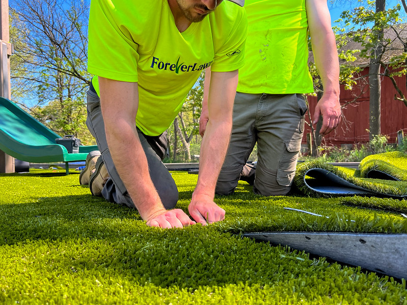 forever lawn emplyee installing artificial turf